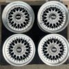 BBS RS three-piece forged split rim wheels featuring a raw silver finish, iconic cross-spoke pattern, polished stepped lips, and original black center caps with chrome BBS lettering
