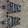 Aftermarket tubular adjustable front lower control arms featuring polyurethane bushings.
