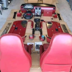 1993 Mazda MX-5 Miata Limited Edition (93LE) Red Interior Conversion Kit laid out on cardboard for a restoration or component sale