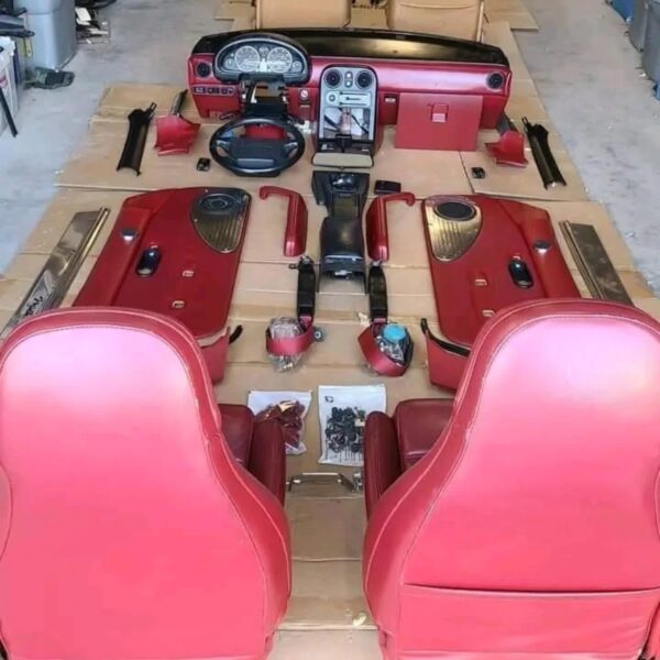 1993 Mazda MX-5 Miata Limited Edition (93LE) Red Interior Conversion Kit laid out on cardboard for a restoration or component sale