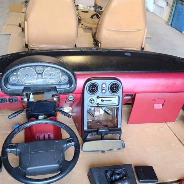1993 Mazda MX-5 Miata Limited Edition (93LE) Red Interior Conversion Kit laid out on cardboard for a restoration or component sale