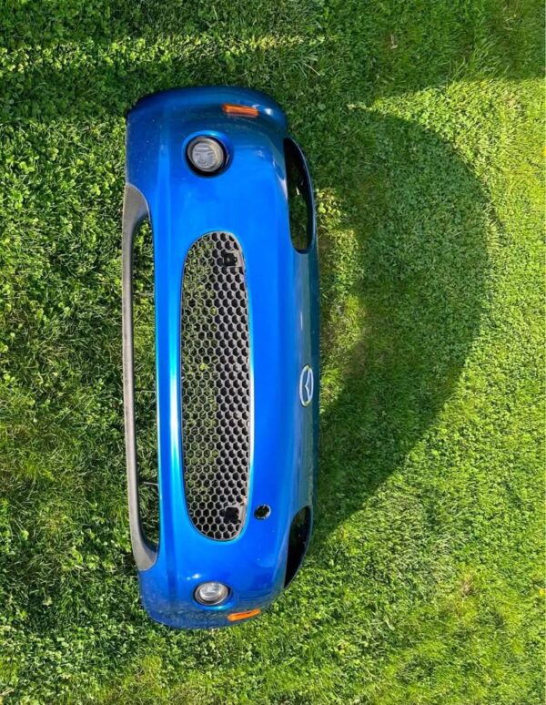 OEM Mazda MX-5 Miata (NB2 / 2001–2005) Front Bumper Cover Assembly in Laser Blue / OEM Blue, complete with fog lights, center grille mesh, emblem, and lower lip.