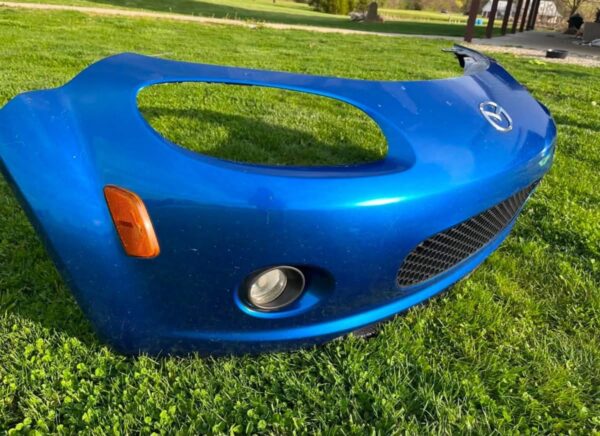 OEM Mazda MX-5 Miata (NB2 / 2001–2005) Front Bumper Cover Assembly in Laser Blue / OEM Blue, complete with fog lights, center grille mesh, emblem, and lower lip.