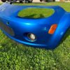 OEM Mazda MX-5 Miata (NB2 / 2001–2005) Front Bumper Cover Assembly in Laser Blue / OEM Blue, complete with fog lights, center grille mesh, emblem, and lower lip.