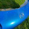 OEM Mazda MX-5 Miata (NB2 / 2001–2005) Front Bumper Cover Assembly in Laser Blue / OEM Blue, complete with fog lights, center grille mesh, emblem, and lower lip.