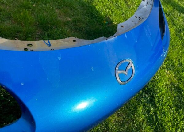 OEM Mazda MX-5 Miata (NB2 / 2001–2005) Front Bumper Cover Assembly in Laser Blue / OEM Blue, complete with fog lights, center grille mesh, emblem, and lower lip.